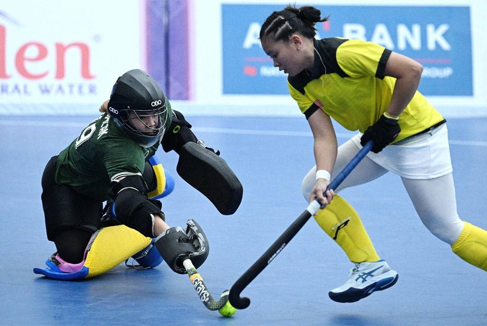 Nor Isahhidun (kanan) mengelecek penjaga gol Thailand Somlak Suttiprapa pada aksi final di Dinosaur Park Hall, Chroy Changvar pada Ahad. - Foto AFP