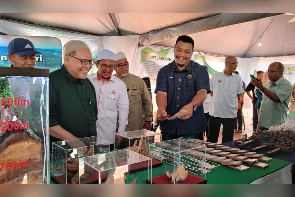 Mohd Amar (dua dari kiri) mendengar taklimat berkaitan peralatan yang digunakan kakitangan Jabatan Perhutanan sempena Sambutan Hari Hutan Antarabangsa ke-52 Peringkat Negeri Kelantan 2023 pada Isnin.