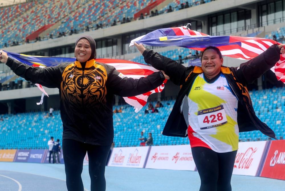 Grace Wong (kanan) dan Nurul Hidayah meraikan kejayaan masing-masing dalam Sukan SEA 2023 di Stadium Nasional Morodok Techo pada Isnin. - Foto Bernama