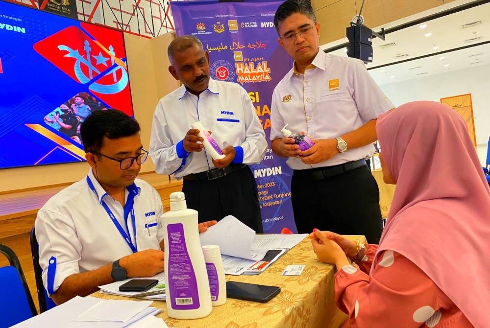 Hairol Ariffein (berdiri kanan) bersama Norman Rajen (kiri) melihat produk usahawan tempatan di Majlis Sesi Padanan Perniagaan Usahawan Produk Halal-Kolobrasi HDC dan Mydin Sempena Jelajah Halal Malaysia 2023 Kelantan pada Isnin.