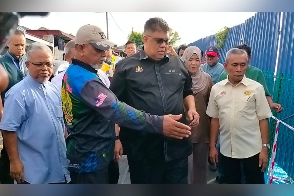 Ab Rauf (dua dari kanan) meninjau kawasan cerun bukit yang berlaku tanah runtuh di Taman Muzaffar Syah di sini, pada Selasa.