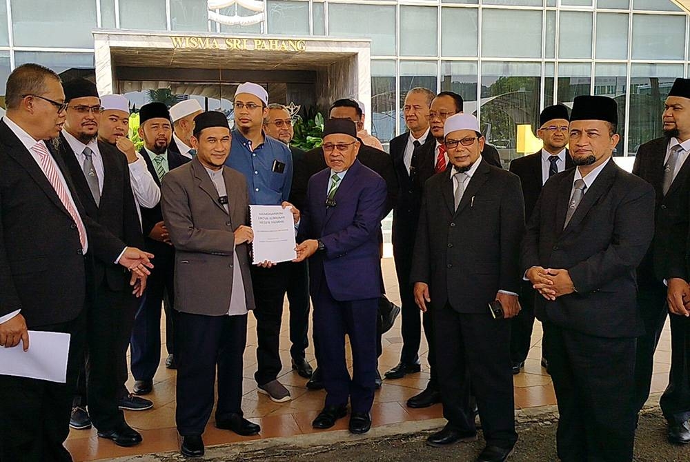 Mohd Zarimi (depan, tiga dari kiri) menyerahkan memorandum isu air kepada Tuan Ibrahim di Wisma Sri Pahang di sini pada Selasa.