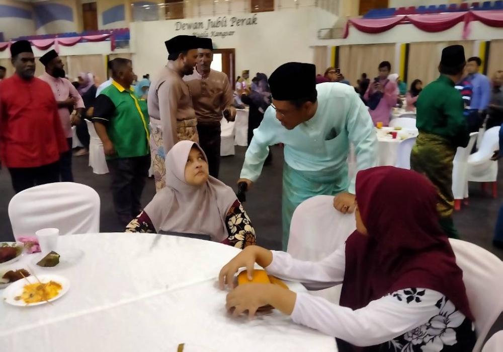 Ahmad Faizal melayani tetamu yang hadir ke majlis Rumah Terbuka Aidilfitri Bersatu Negeri Perak anjuran Bersama Parlimen Kuala Kangsar di Dewan Jubli Perak di sini pada Selasa.