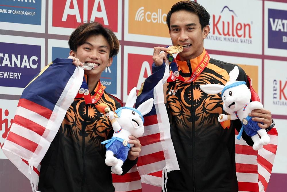 Muhammad Syafiq (kanan) dan Gabriel Gilbert Daim bergambar bersama pingat masing-masing selepas beraksi dalam acara 3 meter papan anjal lelaki pada Sukan SEA 2023 di Pusat Akuatik Nasional Morodok Techo hari ini. - Foto Bernama