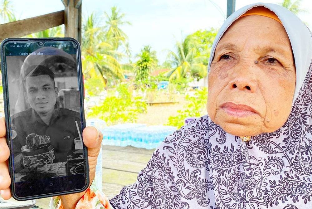 Noriah menunjukkan gambar anak lelakinya, Lans Koperal Mohd Idris yang meninggal dunia pada Selasa selepas dua hari dirawat akibat dipatuk ular tedung.