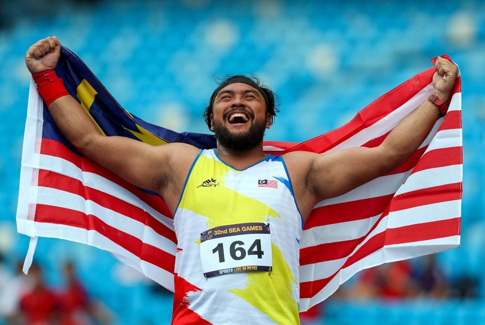 Mohd Ziyad bersama Jalur Gemilang selepas berjaya meraih pingat gangsa dalam acara akhir lontar peluru pada Sukan SEA 2023 Phnom Penh Kemboja di Stadium Nasional Morodok Techo hari ini. - Foto Bernama