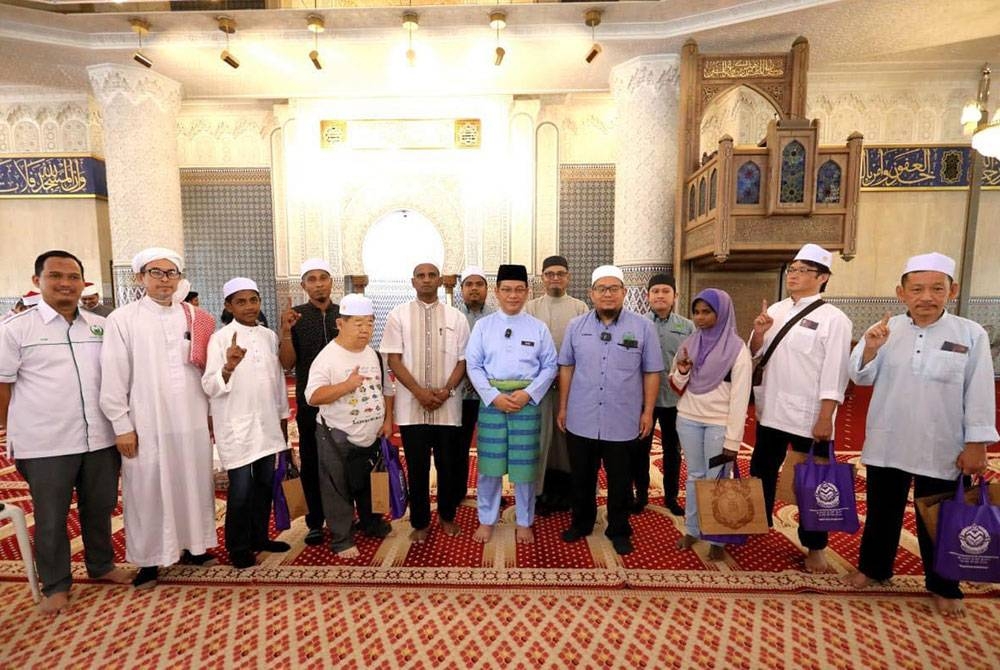 Mohd Na&#039;im (lima dari kanan) bergambar dengan saudara baharu yang memeluk Islam di Masjid Negara.