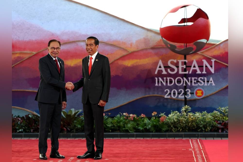 Anwar (kiri) disambut Joko Widodo ketika menghadiri Sidang Kemuncak ASEAN ke-42 2023 di bandar Manggarai Barat, Kepulauan Flores di Wilayah Nusa Tenggara Timur hari ini. - Foto Bernama