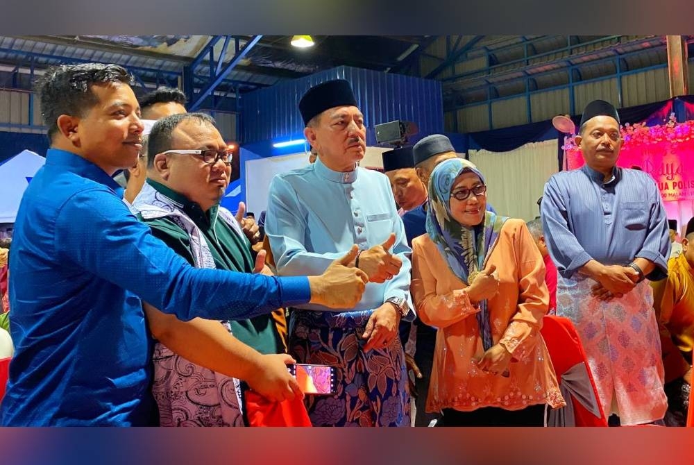 Muhamad Zaki (tengah) bergambar bersama tetamu yang hadir pada Majlis Sambutan Hari Raya Aidilfitri Peringkat IPD Pasir Puteh pada malam Selasa.