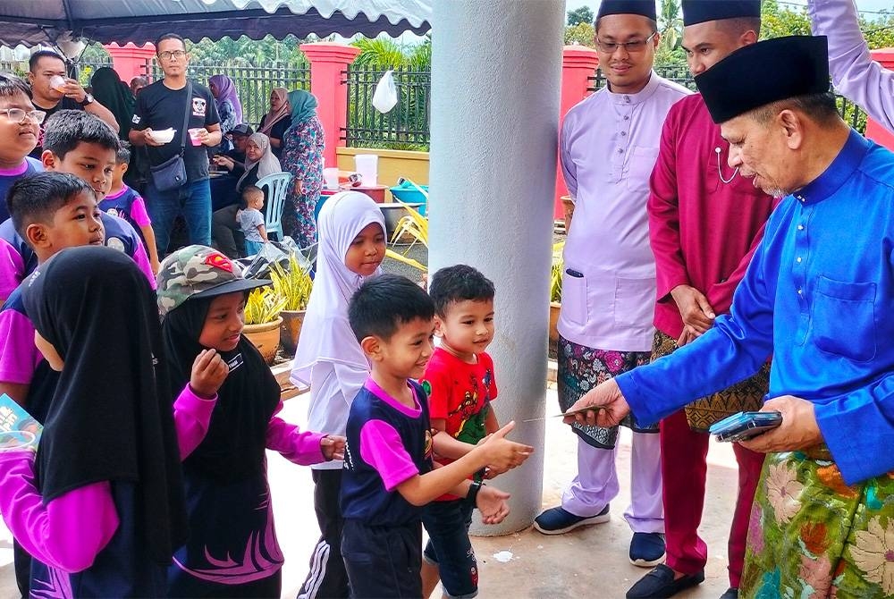 Razak menyampaikan sumbangan duit raya untuk kanak-kanak sempena sambutan tersebut di Dewan Mat Kilau, Jengka 24 pada Rabu