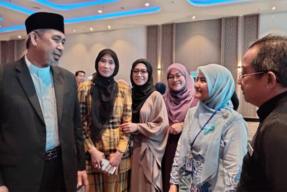 Dr Izani (kiri) bersama ibu bapa dan kakitangan JKN selepas merasmikan Majlis Sambutan Hari Autisme Sedunia Peringkat Negeri Kelantan 2023 pada Rabu.