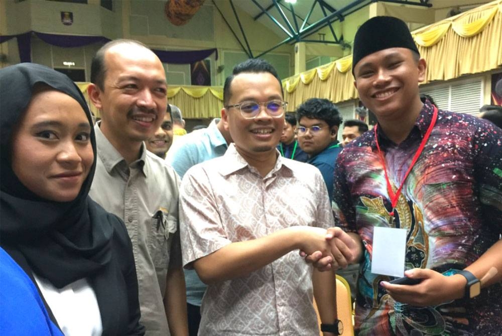 Nik Nazmi (dua dari kanan) bersalam dengan pelajar selepas Townhall Madani @ UiTM di Machang, di sini pada Khamis.