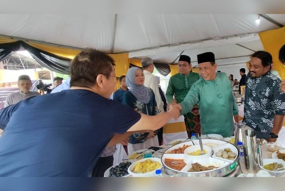 Aminuddin (dua dari kanan) bersalaman dengan tetamu yang hadir pada Majlis Jamuan Hari Raya Aidilfitri pentadbiran daerah Kuala Pilah pada Khamis.