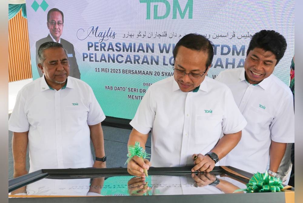 Ahmad Samsuri (tengah) disamping Yahaya (kiri) dan Najman (kanan) ketika menyempurnakan majlis pelancaran logo baharu dan perasmian Wisma TDM di Jalan Kamaruddin, di Kuala Terengganu pada Khamis.