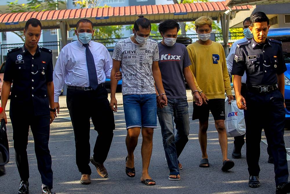 Ameerul Ridhuan (tiga dari kiri), Mohd Lutfi dan Mohd Rusdy diiringi polis sebaik tiba di mahkamah.