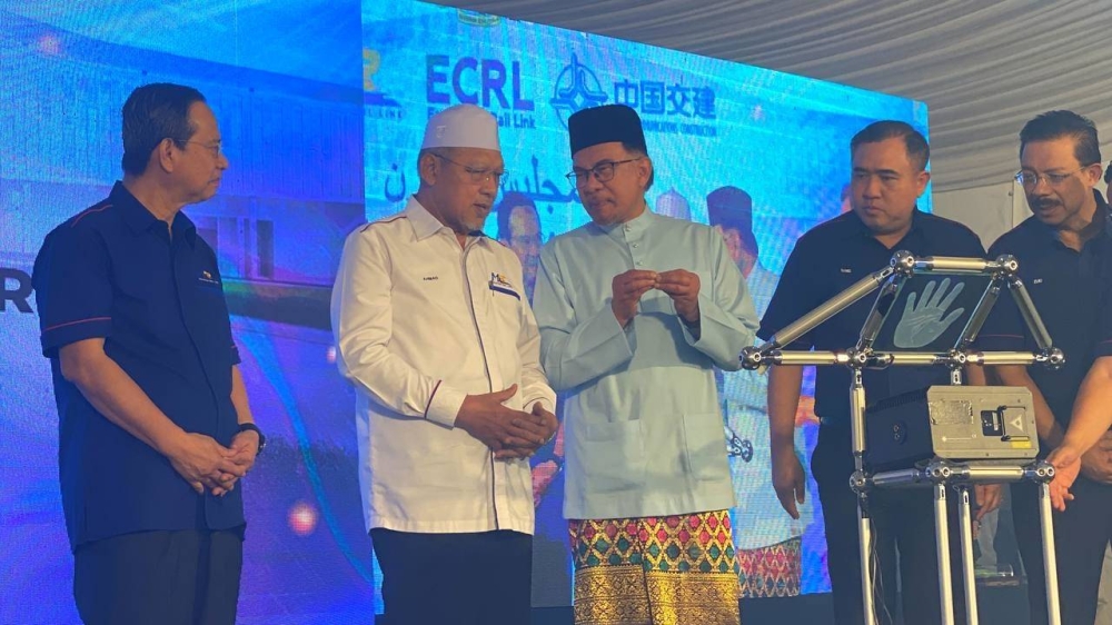 Anwar (tiga dari kanan) bersama Ahmad (dua dari kiri) pada Majlis Pelancaran Pembinaan Stesen Pertama ECRL Tunjong di Bandar Baru Tunjong, Kota Bharu pada Jumaat.
