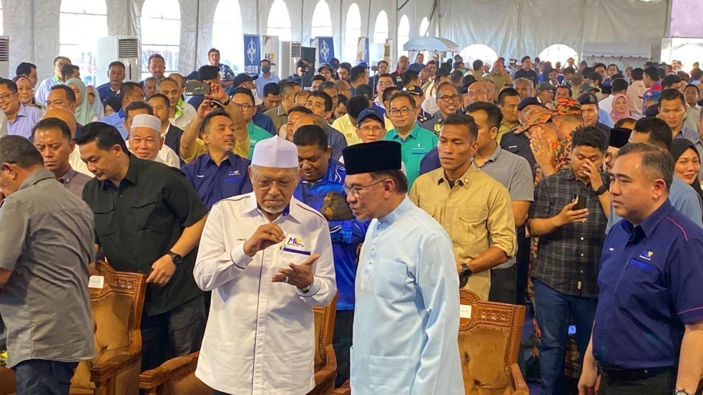 Anwar (kanan) dan Ahmad membincangkan sesuatu semasa Majlis Pelancaran Pembinaan Stesen Pertama Laluan Rel Pantai Timur (ECRL) di Bandar Baru Tunjong, Kota Bharu pada Jumaat.