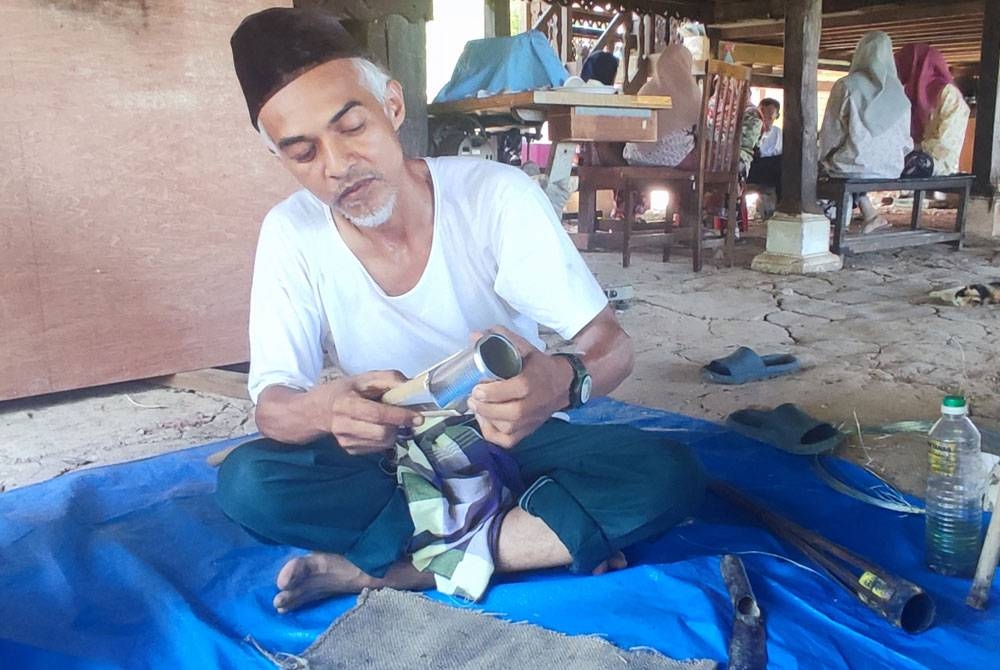 Zainuddin Ismail menunjukkan cara membuat jamung.