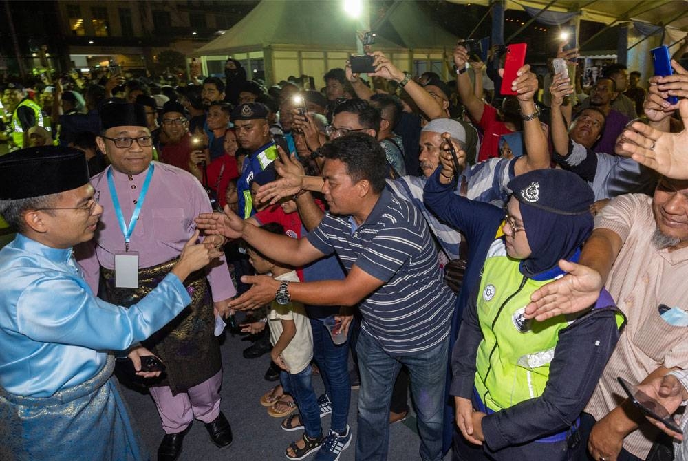 Fahmi bersalaman bersama orang ramai ketika hadir pada Majlis Rumah Terbuka Malaysia Madani di pekarangan Stadium Sultan Muhammad IV. - Foto Bernama