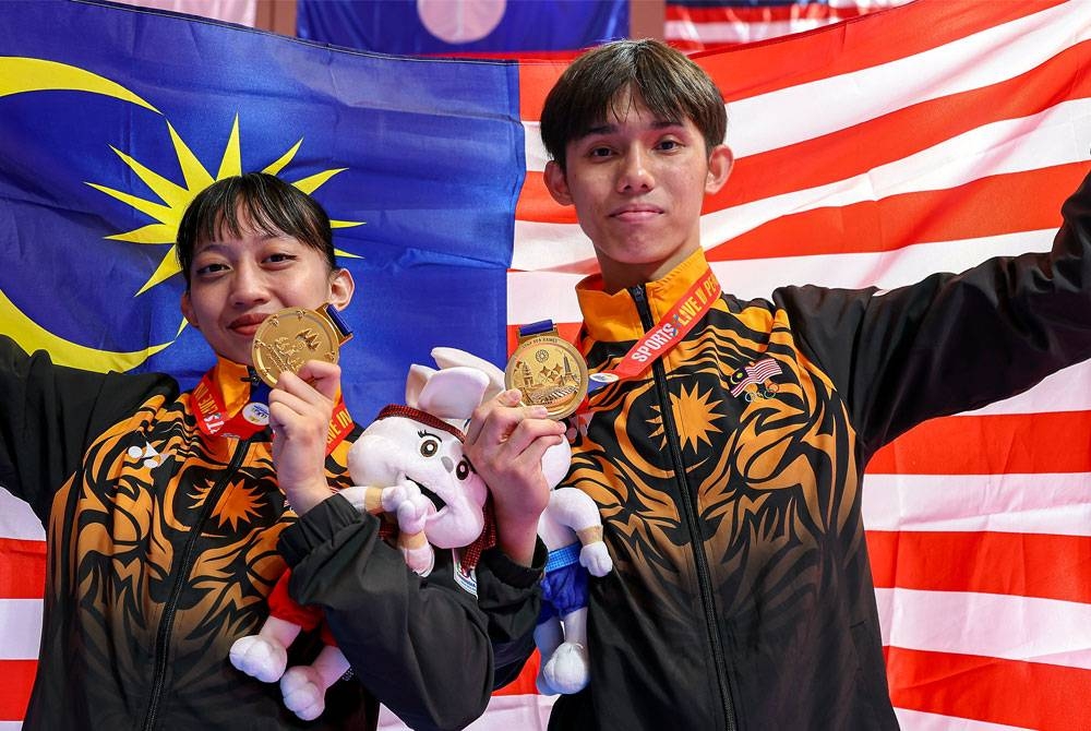 Jason Loo (kanan) dan Nurul Hidayah bersama pingat selepas beraksi pada acara akhir Poomsae Campuran Sukan SEA 2023 di Chroy Changvar Convention Centre, Phnom Penh pada Jumaat.