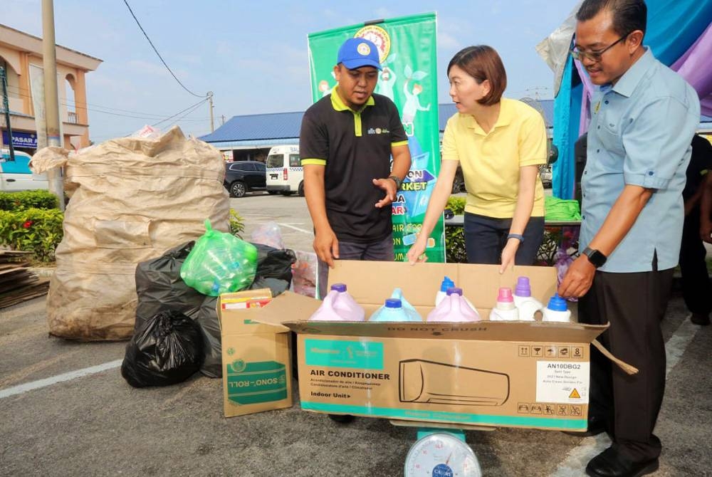 Sandrea (tengah) melihat barangan kitar semula yang dihantar komuniti setempat di bawah program Eco Green Market.