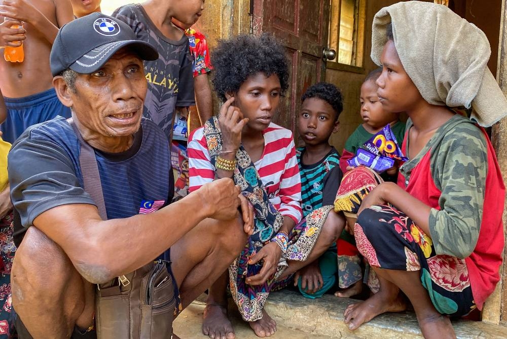 Asin (kiri) bersama ahli keluarga kelihatan sugul ketika ditemui pemberita di Kampung Aring 5, Gua Musang pada Sabtu. - Foto Bernama