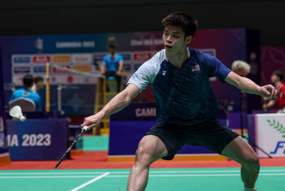 Aksi pemain perseorangan badminton negara Leong Jun Hao ketika menentang pemain Singapura pada peringkat pusingan 16 sempena Sukan SEA 2023 Phnom Penh, Kemboja di Stadium Badminton Morodok Techo. - Foto Bernama.