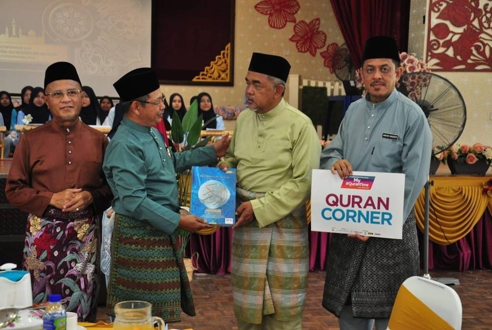 Hashim (dua dari kanan) menyerahkan sumbangan al-Quran kepada Pengetua SMK Sri Pagi, Jamri Ahmad (dua dari kiri).