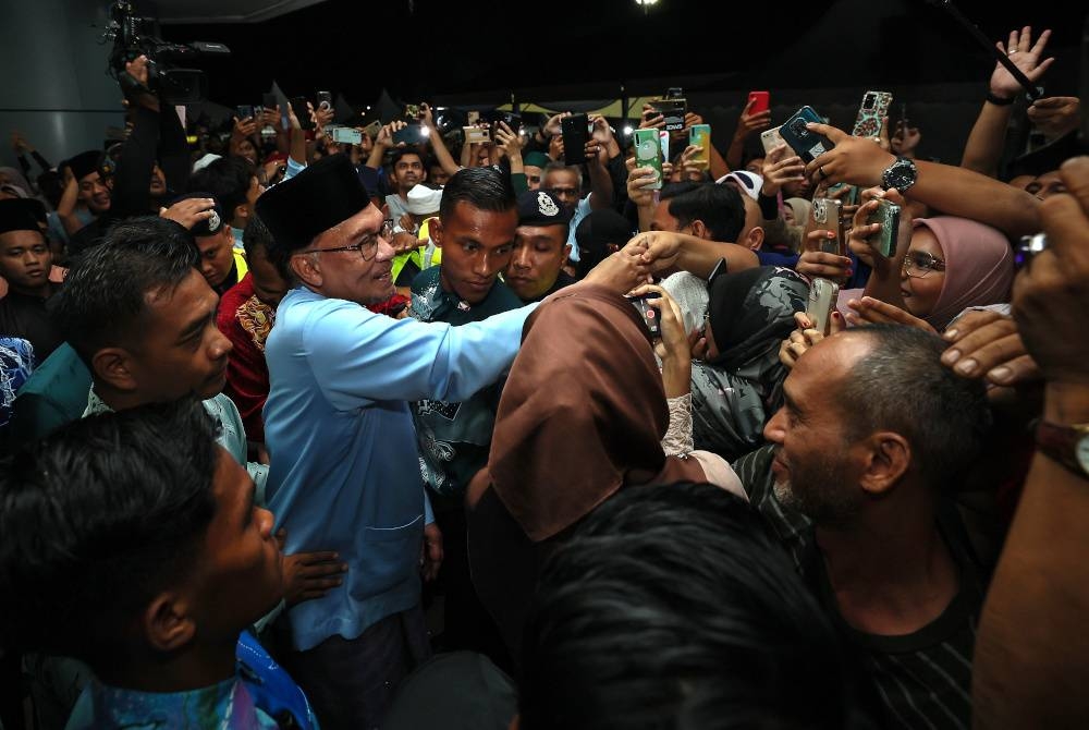 Perdana Menteri Datuk Seri Anwar Ibrahim (dua, kiri) bersalaman dan beramah mesra bersama orang ramai pada Majlis Rumah Terbuka Malaysia Madani di Universiti Sultan Zainal Abidin (UniSZA). - Foto Bernama