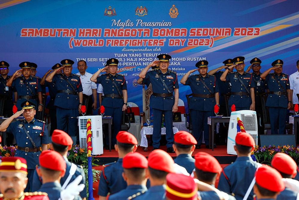 Yang Dipertua Negeri Melaka Tun Mohd Ali Rustam (tengah) melakukan tabik hormat kepada anggota dan pegawai Jabatan Bomba dan Penyelamat sempena Sambutan Hari Bomba Sedunia di Memorial Pengisytiharan Kemerdekaan dekat Banda Hilir hari ini. - Foto Bernama