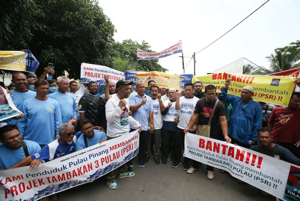 Ibrahim (kemeja biru, tengah) bersama nelayan yang menyertai Perhimpunan Aman Bantahan Terhadap Projek PSI di Sungai Batu, Teluk Kumbar pada Sabtu.