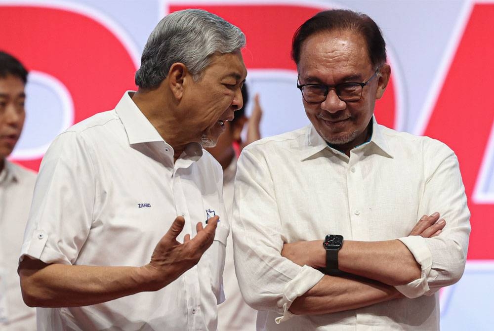 Anwar dan Ahmad Zahid berbual-bual selepas Konvensyen Nasional Kerajaan Perpaduan di Pusat Dagangan Dunia Kuala Lumpur hari ini. - Foto Bernama