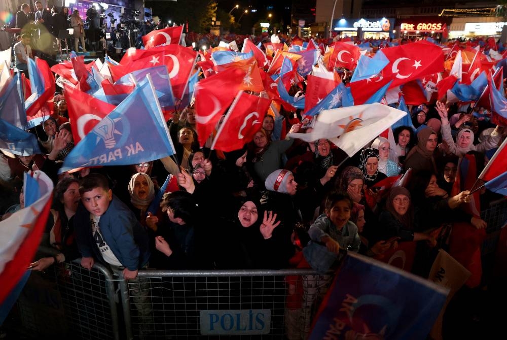 Penyokong Presiden Turkiye dan Parti Keadilan dan Pembangunan (AK) kibarkan bendera semasa menunggu keputusan pilihan raya umum Turkiye di ibu pejabat Parti AK di Ankara pada Ahad. - Foto AFP