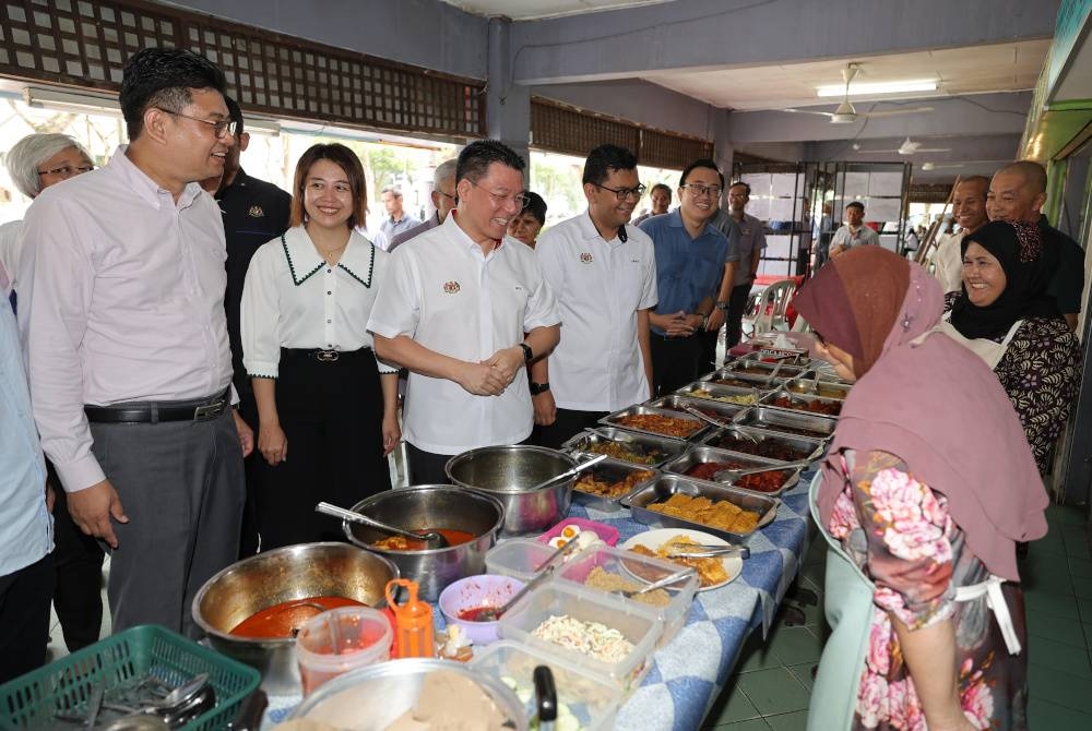 Menteri Pembangunan Kerajaan Tempatan Nga Kor Ming beramah mesra bersama sebahagian peniaga di Anjung Selera Laman Tasik Pandan ketika meninjau keperluan kerja-kerja menaik taraf dan baik pulih infrastruktur sempena lawatan kerjanya di kawasan tersebut. - Foto Bernama.