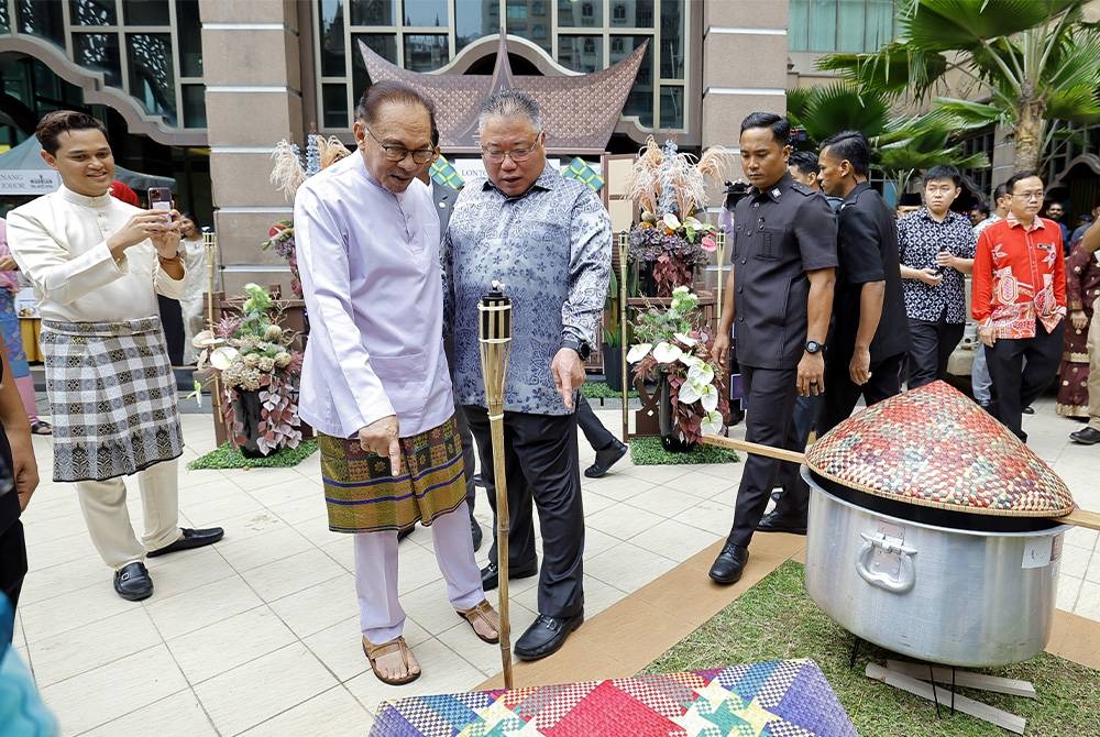 Anwar bersama King Sing melawat gerai makanan pada Majlis Sambutan Aidilfitri Kementerian Pelancongan di Putrajaya pada Isnin. - Foto Bernama