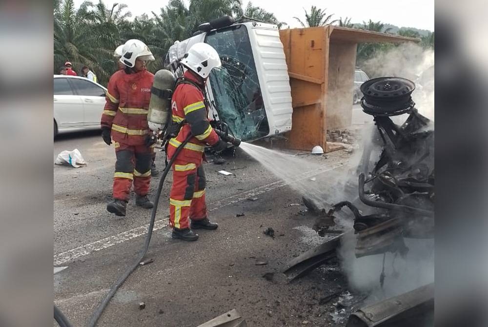 Anggota bomba memadam kebakaran sebuah van yang terbalik dan terbakar dalam kemalangan, pada Isnin.