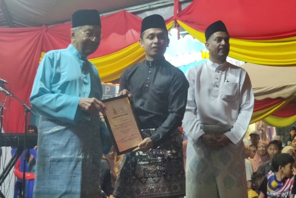 Mahathir (kiri) menyampaikan penghargaan kepada penaja Majlis Jamuan Raya Aidilfitri DUN) Jeram di Bandar Puncak Alam di sini pada Isnin.