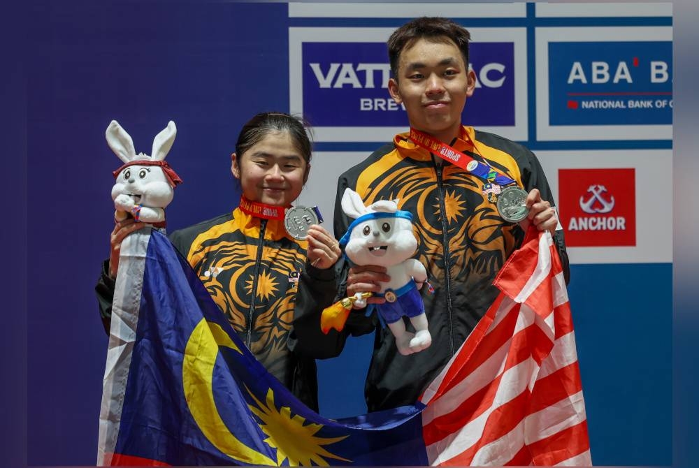 Roy King (kanan) dan Su Yin merangkul pingat perak selepas tewas kepada regu Indonesia di Sukan SEA 2023 Kemboja pada Selasa. - Foto Bernama