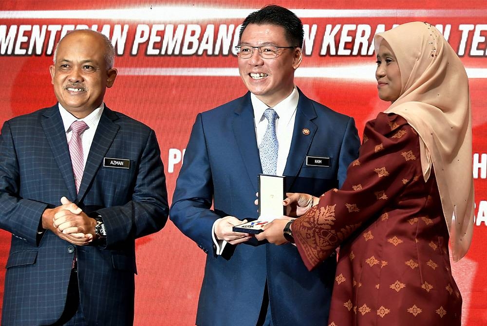 Kor Ming (tengah) menyampaikan Pingat Perkhidmatan Cemerlang (PPC) kepada Mazisalwani Mahyuddin (kanan) pada Majlis Apresiasi Kecemerlangan Kementerian Pembangunan Kerajaan Tempatan 2022 di Pusat Konvensyen MBSA Seksyen 13 pada Selasa. - Foto Bernama