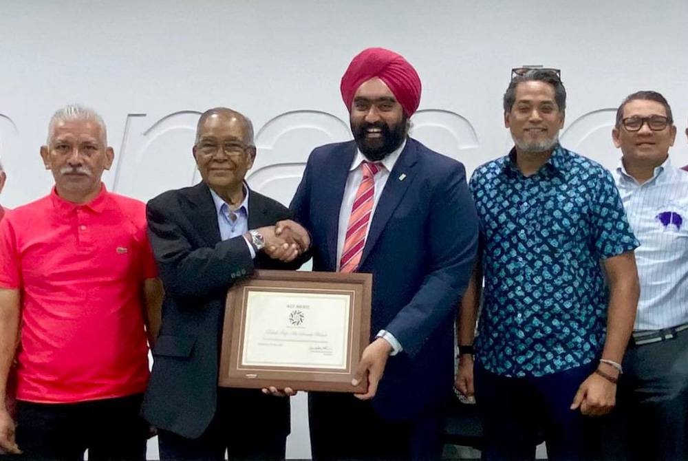 Amarjit menyerahkan Anugerah Merit ACF kepada Abu Samah sambil diperhatikan barisan Naib Presiden PKBM di Nilai pada Selasa.