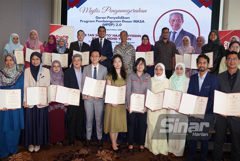 Muhyiddin bergambar bersama penerima Geran Penyelidikan Program Pembangunan Dasar Masa (MPDP) 2.0 yang diadakan di Hotel Tamu & Suites, Kuala Lumpur pada Rabu. - Foto ROSLI TALIB/SINAR HARIAN