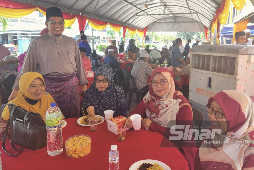 Sallehuddin (berdiri dua dari kiri) beramah mesra bersama tetamu yang hadir pada Majlis Sambutan Aidilfitri PPK Sungai Besar pada Selasa.