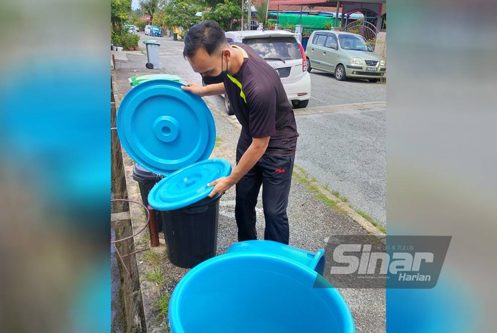 Mohd Nizar menunggu penghantaran bekalan air melalui lori setelah empat hari terputus bekalan di Taman Murni, Gurun.