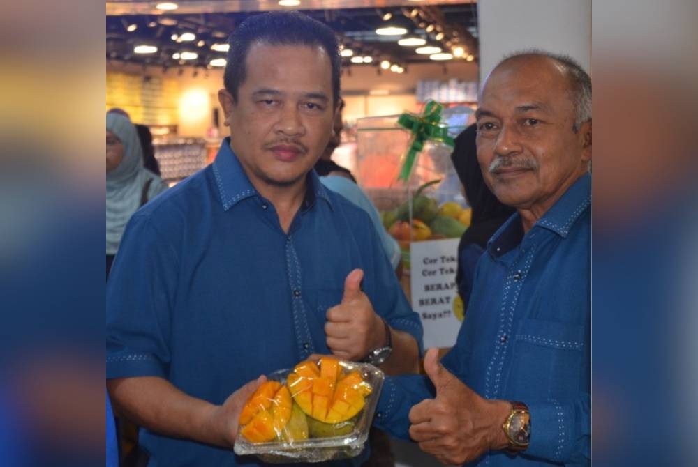 Exco Pertanian dan Industri Asas Tani Negeri Kedah, Datuk Azman Nasrudin (kiri) bersama Ramli menunjukkan tanda bagus ketika melawat Fiesta Harumanis D'Aman di Sungai Petani.