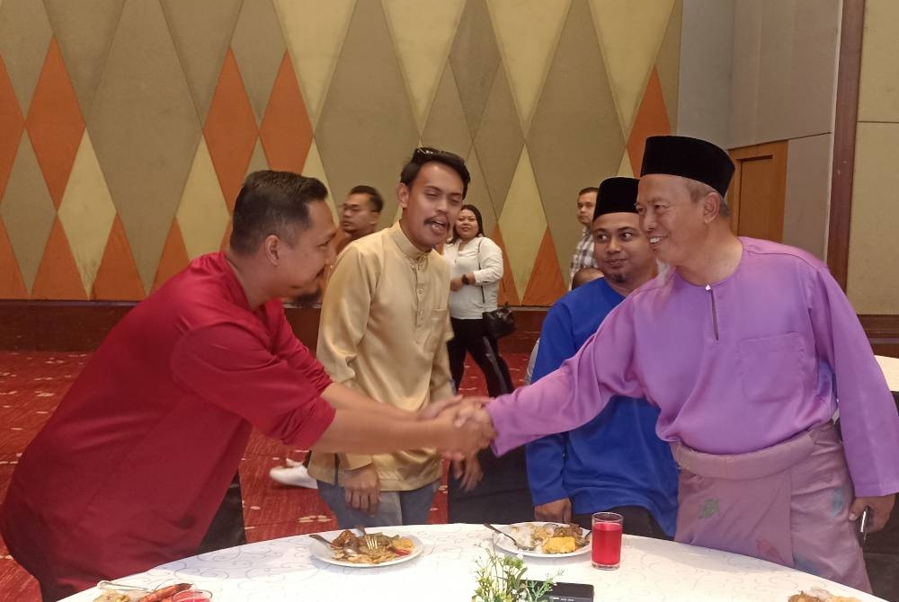 Anuar ( kanan) beramah mesra dengan orang ramai yang hadir pada Majlis Rumah Terbuka Aidilfitri SAJ Ranhill di Persada pada Khamis.