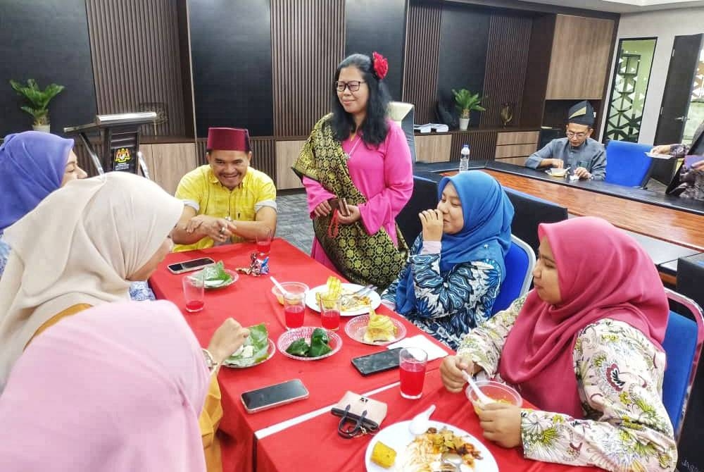 Sharifah Zakiah (tiga dari kanan) melayani tetamu yang hadir ke Majlis Rumah Terbuka JAS Negeri Kedah di sini pada Khamis.