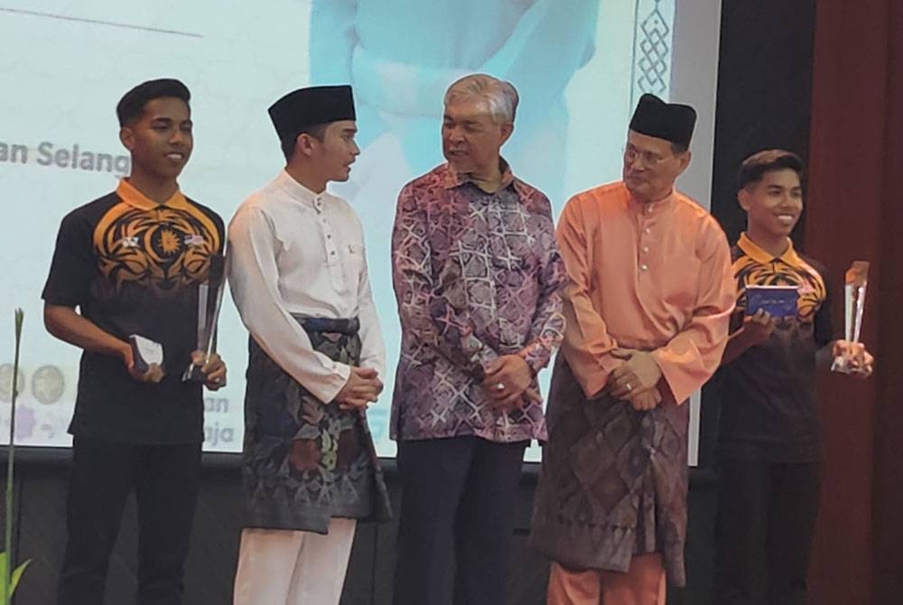 Ahmad Zahid (tiga dari kanan) bertanya sesuatu dengan Yang Dipertua Majlis Perwakilan Pelajar (MPP) UiTM Shah Alam, Mohamed Yusuf Hassan Roslan (dua dari kiri) sambil diperhatikan, Pengerusi Lembaga Pengarah UiTM, Profesor Emeritus Datuk Dr Raduan Che Rose (dua dari kanan) semasa Majlis Riang Raya MPP UiTM di Dewan Berlian, UiTM Puncak Alam di sini pada Khamis.