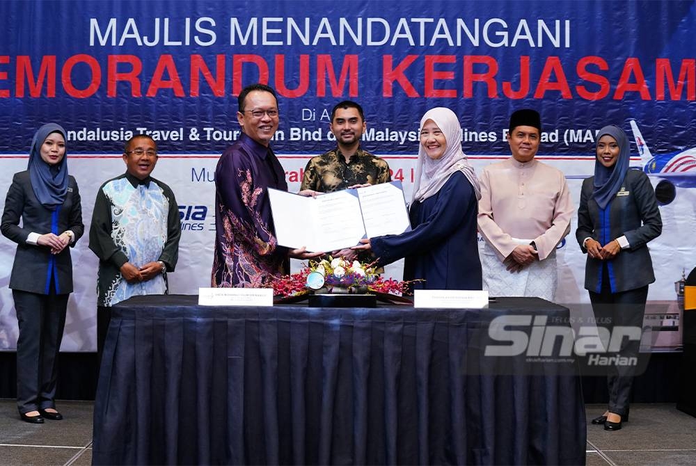 Pengarah dan Penasihat Undang-Undang Andalusia Sdn Bhd, Ida Riswana Idris (kanan) dan Ketua Pegawai Operasi Amal by Malaysia Airlines, Muhammad Najmi Mansor menandatangai memorandum kerjasama dalam majlis yang berlangsung di Hotel Intercontinental pada Khamis. Turut menyaksikan Timbalan Menteri Pelancongan, Seni dan Budaya, Khairul Firdaus Akhbar Khan (belakang, tengah). Foto SINAR HARIAN / MOHD HALIM ABDUL WAHID