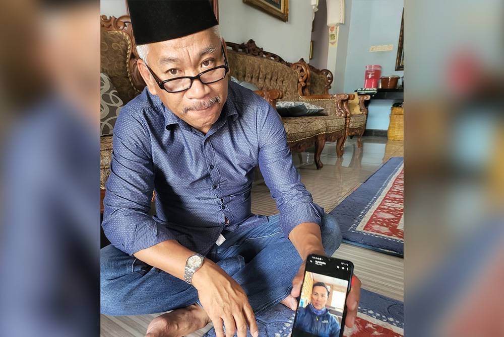 Awang Asim menunjukkan gambar terakhir yang dikongsikan adiknya, Awang Askandar sebelum memulakan pendakian ke kem pertama dalam misinya menawan puncak Gunung Everest.