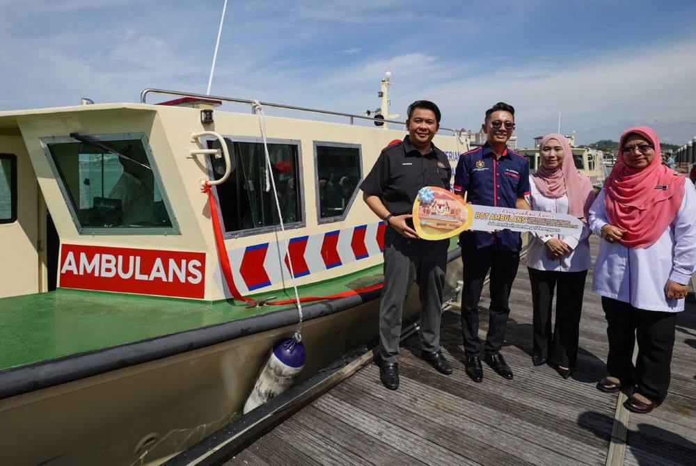 Lukanisman (kiri) menyerahkan replika kunci bot sebagai simbolik Majlis Penyerahan Bot Ambulans Klinik Kesihatan Pulau Perhentian dan Pulau Redang di Jeti Pulau Duyong, pada Sabtu. - Foto Bernama